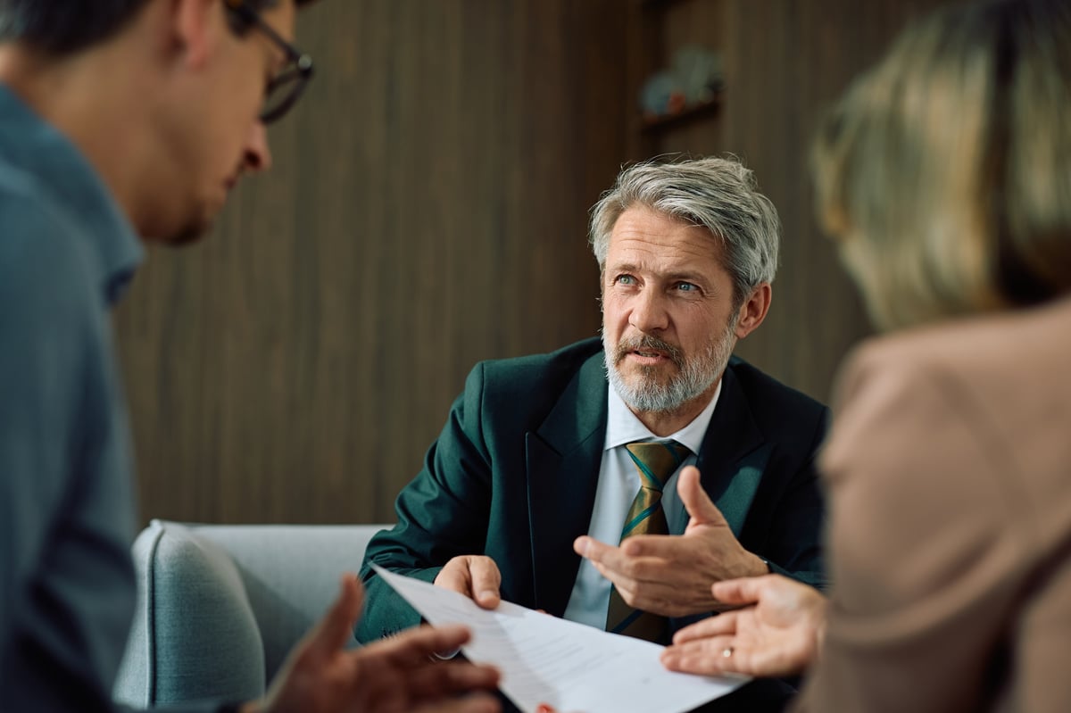 A financial advisor talking with a couple over paperwork during their meeting